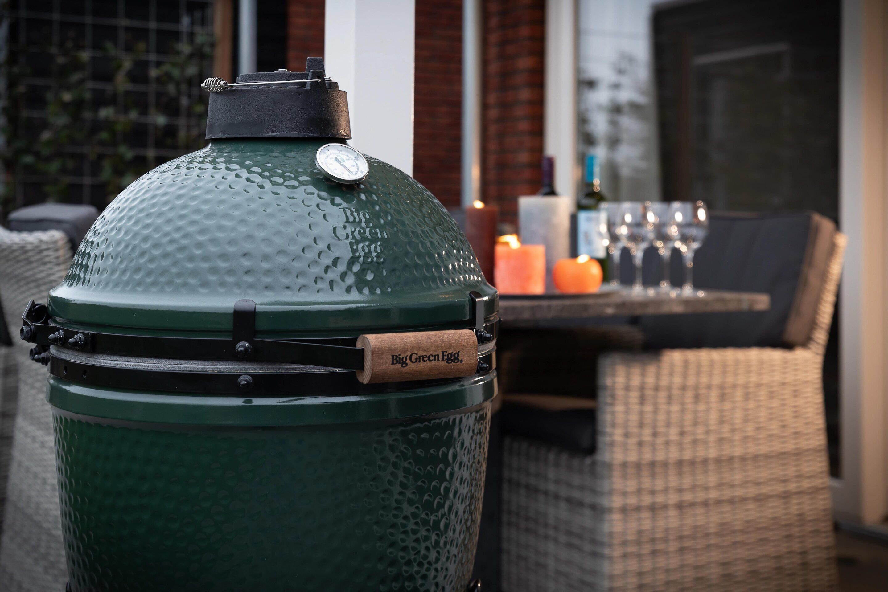 A green outdoor grill with a pressure gauge and a label reading "Big Green Egg."