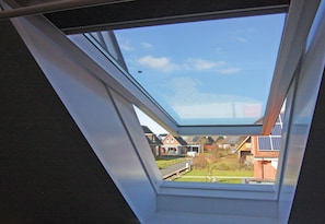 A skylight window with a view of residential houses and solar panels. - Terraced House, Friedrichkoog-spitze (Friedrichskoog)