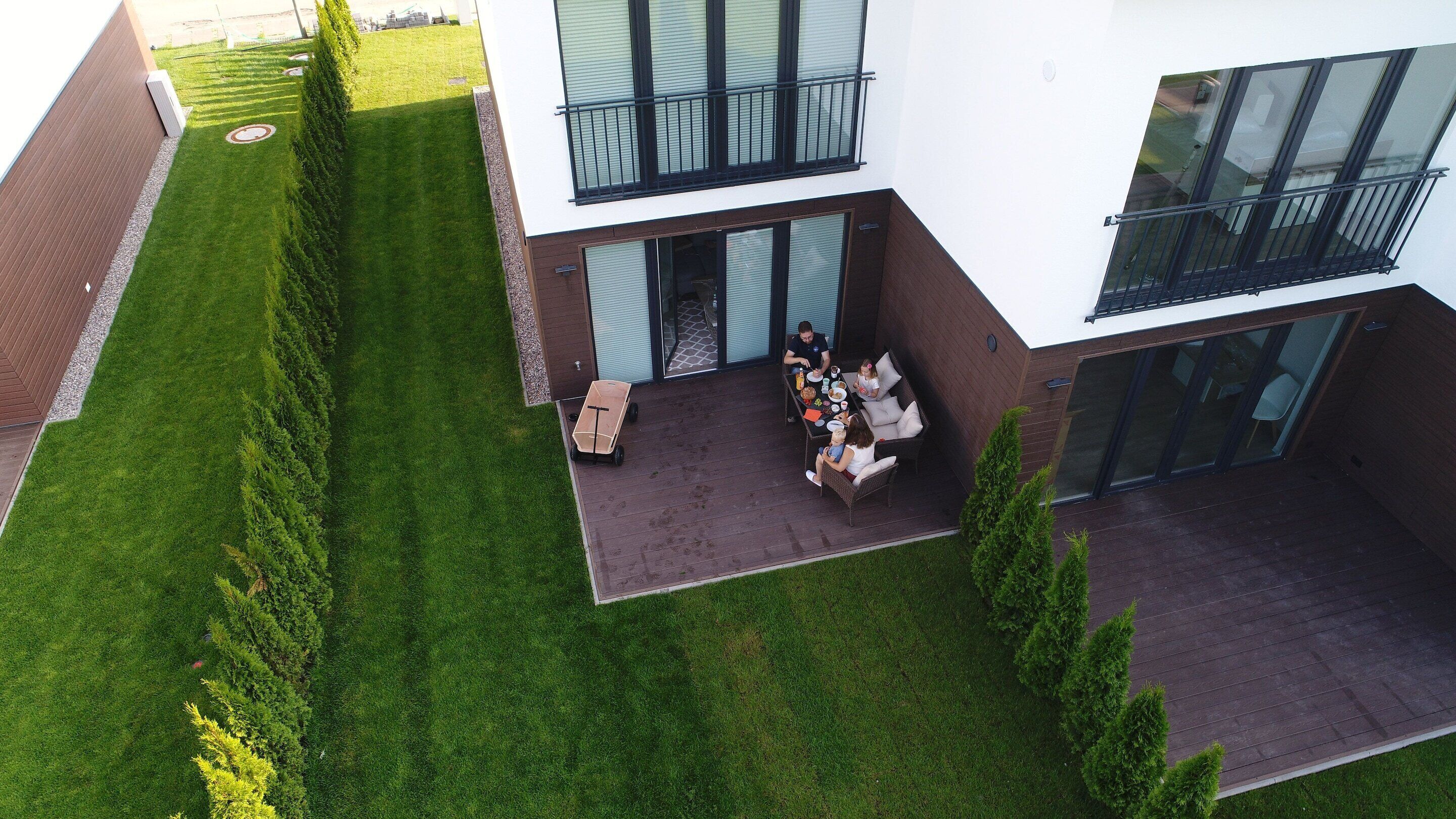 A modern two-story house with a covered patio area.
