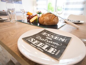 A dining table with a plate of food, a loaf of bread, and a glass of water.