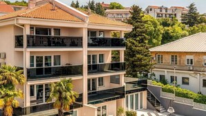 Et hotel med flere etager, en pool på taget, udendørs siddepladser og udsigt til omkringliggende bygninger.