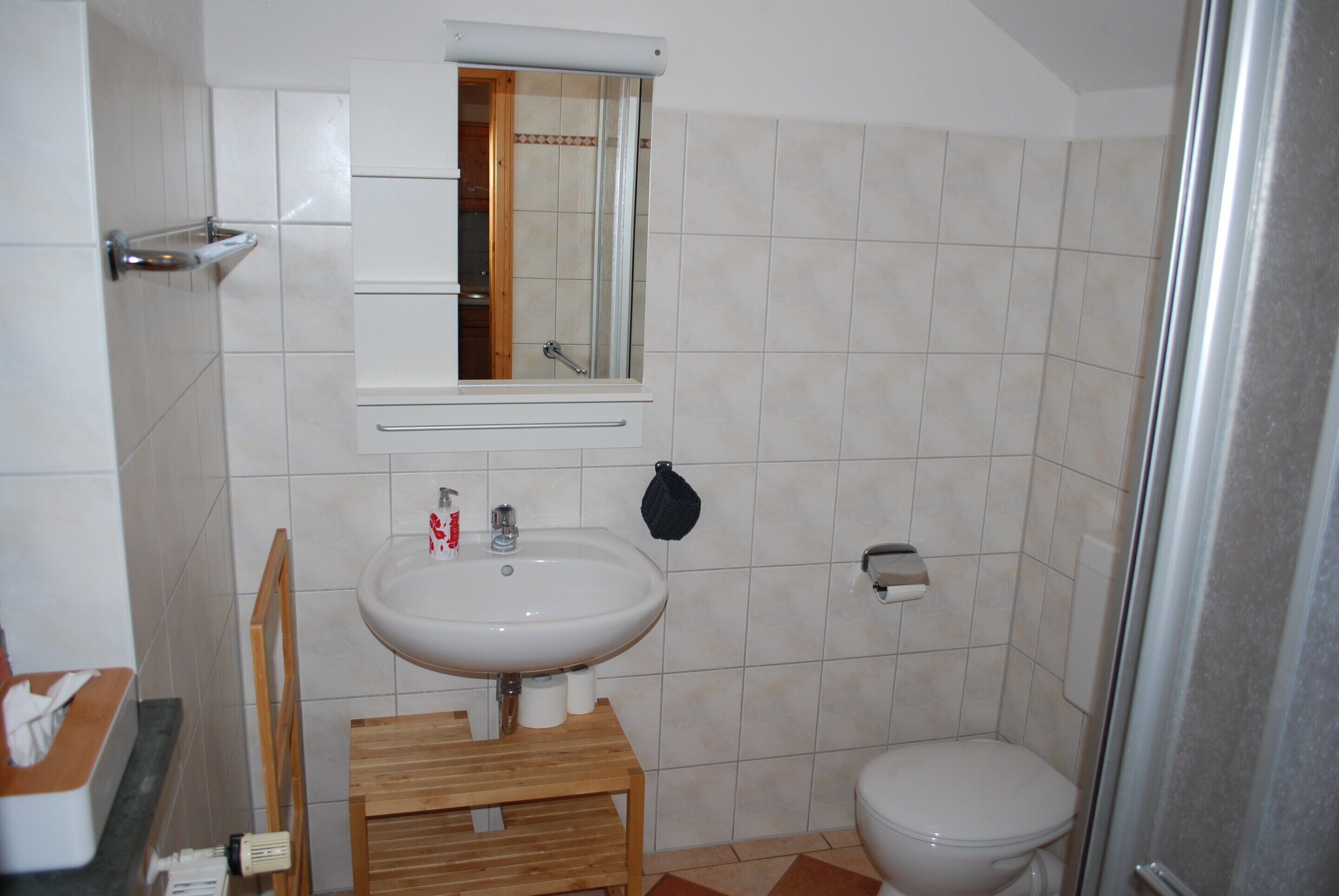 Ein Badezimmer mit Waschbecken, Spiegel und Toilette.