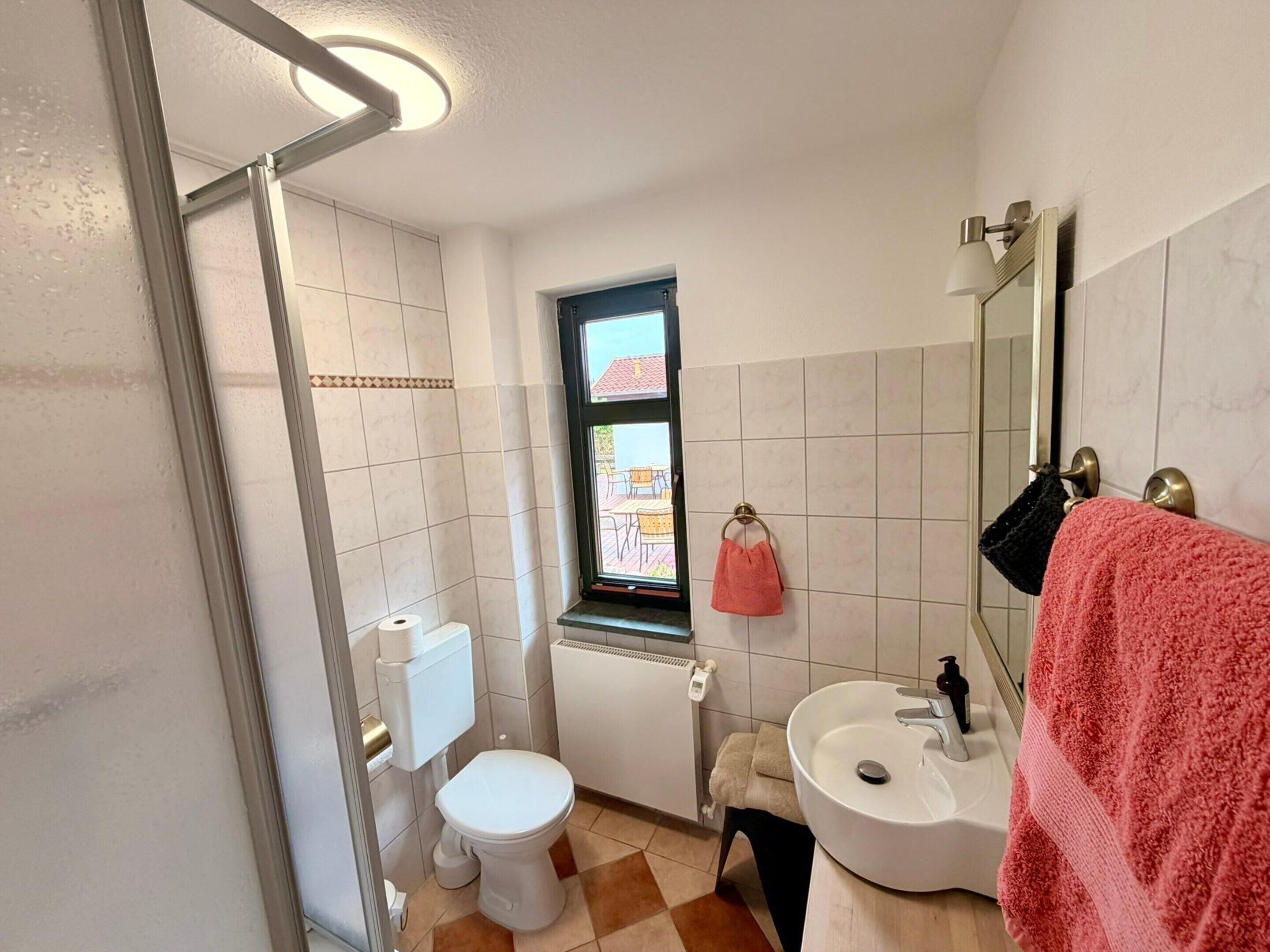Un bagno piccolo e funzionale, con il water, il lavandino e una finestra.