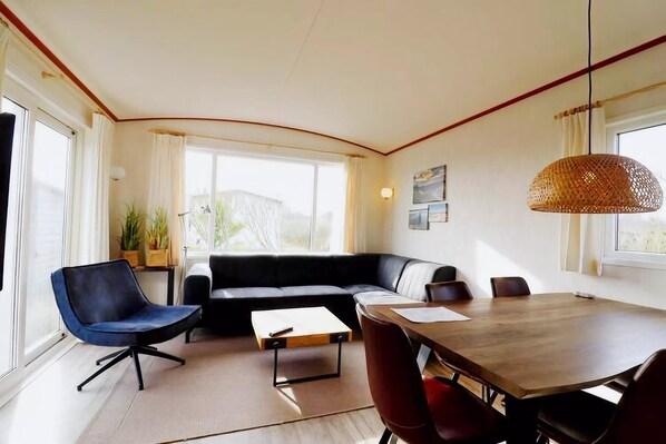 Una sala moderna con un sofá, una mesa de comedor y una silla.