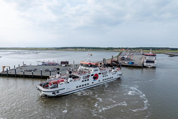 Un ferry atracado en un muelle, con una embarcación grande marcada