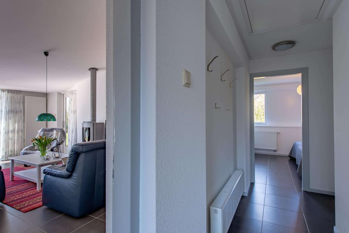 Una sala de estar moderna con un sofá azul, una mesa de centro blanca y una lámpara verde.