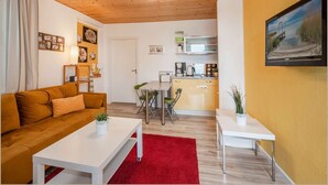 Ein gemütlicher Wohnraum mit Holzboden, einer Küchenzeile, einem Essbereich und einem Sofa.