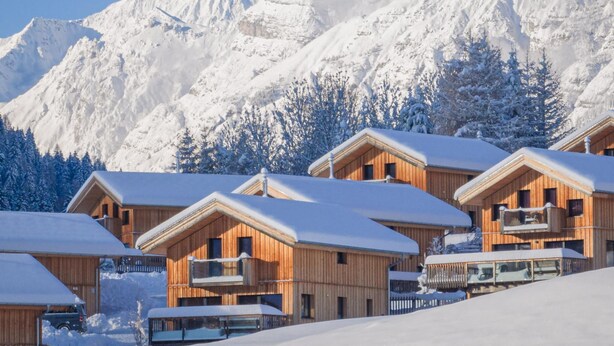 A row of wooden cabins with snow-covered roofs, set against a backdrop of snow-capped mountains. - Gorgeous Chalet in Steinach am Brenner Near Ski Area (Steinach am Brenner)