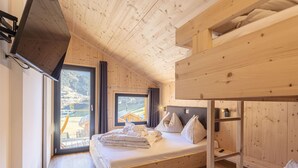 A wooden cabin bedroom with a bunk bed, a large window, and a view of a rural landscape. - Gorgeous Chalet in Steinach am Brenner Near Ski Area (Steinach am Brenner)