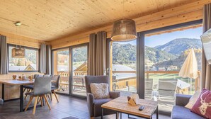 A modern interior with a wooden ceiling, large windows offering mountain views, a dining area, and seating with a view. - Gorgeous Chalet in Steinach am Brenner Near Ski Area (Steinach am Brenner)