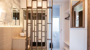 Une salle de bain moderne avec un meuble-lavabo en bois, un grand miroir et des toilettes.