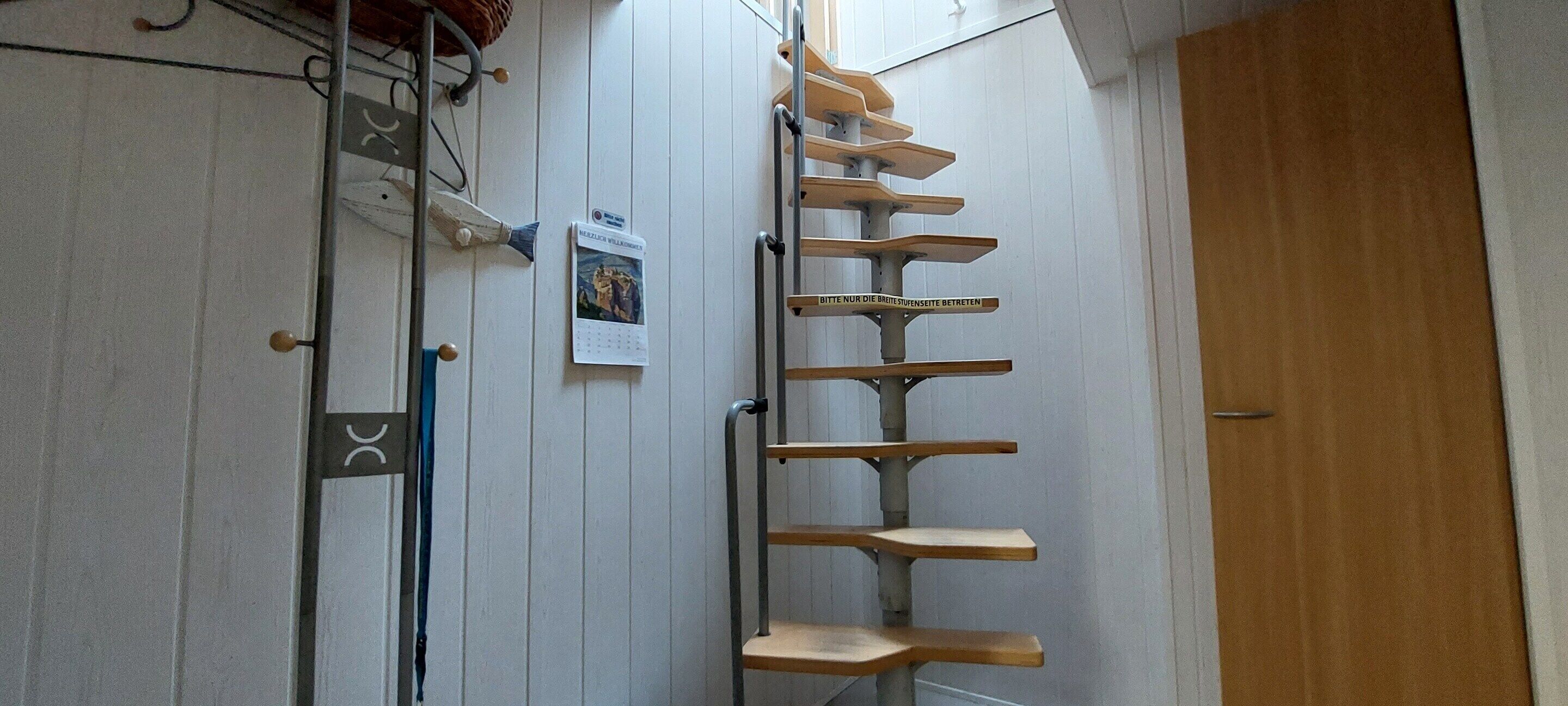Un escalier avec des marches en bois menant à une porte.