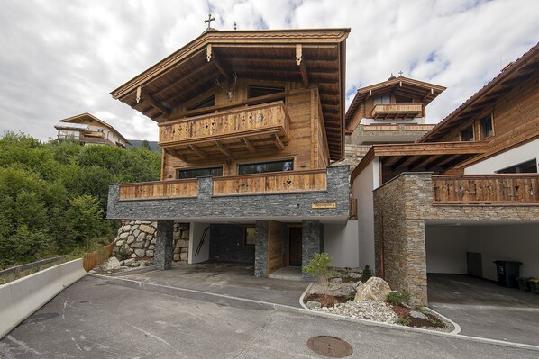 Un bâtiment moderne à plusieurs étages, doté de balcons en bois, d’éléments décoratifs en pierre et d’une façade en pierre.