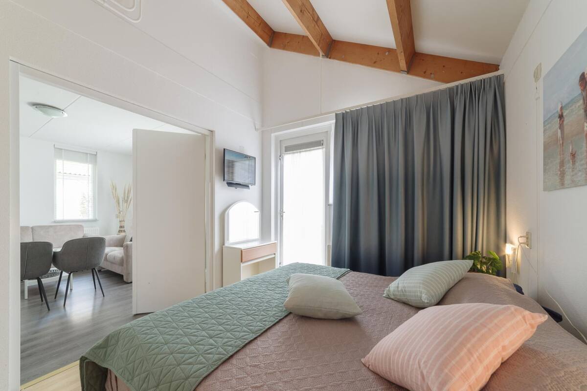 Une chambre à coucher avec un lit, un bureau, une chaise et une fenêtre.