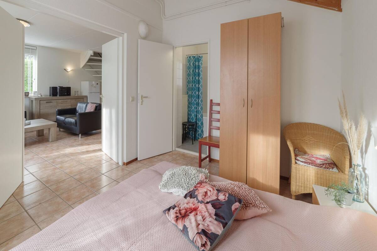 Une chambre à coucher avec un lit, une armoire, une chaise et une petite table.