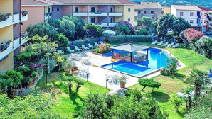 A hotel with a swimming pool surrounded by lounge chairs and greenery. - Residence I Mirti Bianchi, Santa Teresa Gallura (Santa Teresa di Gallura)