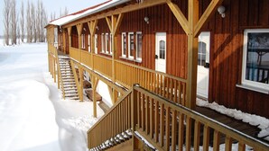 Una baita di legno con un portico coperto e una scala che conduce all'ingresso.