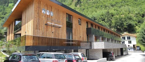 Un edificio moderno con fachada de madera y un letrero que dice 'Neukirchen Wildkogelbahnen'.
