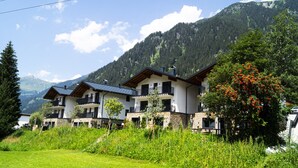 A two-story chalet with balconies, surrounded by lush greenery and mountains. - Graceful Chalet in Gaschurn With Sauna (Gaschurn)
