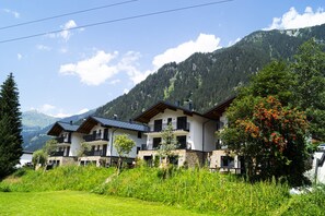A two-story chalet with balconies, surrounded by lush greenery and mountains. - Graceful Chalet in Gaschurn With Sauna (Gaschurn)