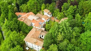 An aerial view of a residential area with terraced houses surrounded by dense greenery. - Holiday Home With Garden and Shared Pool (San Marcello Piteglio)