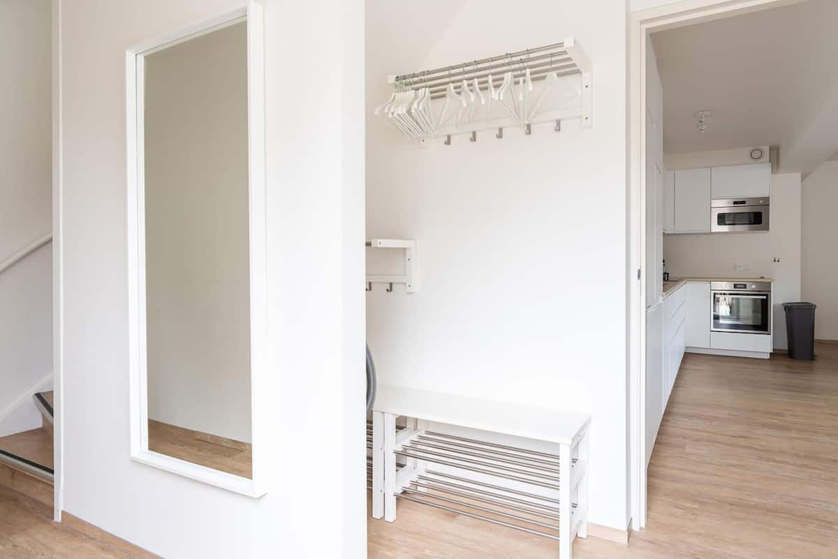 Eine moderne Küche mit weißen Schränken, einem Backofen und einer Mikrowelle.
