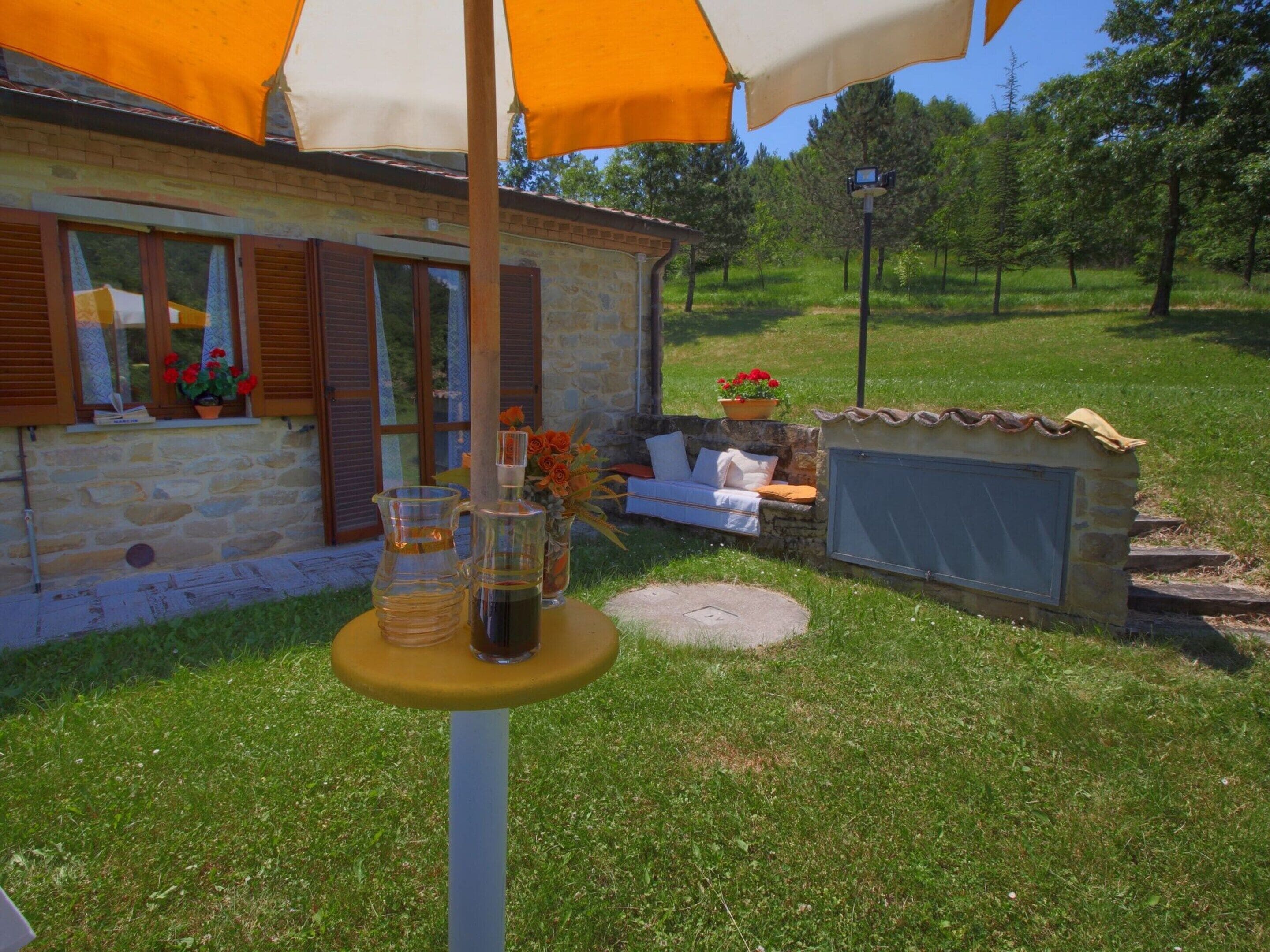 A stone building with a window, a small outdoor seating area, and a table with drinks.