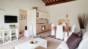A modern living room with a sofa, coffee table, and a TV on the wall. - Modern Holiday Home in Foligno - Loc. With Pool (Foligno)