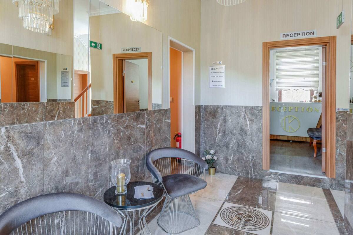 A reception area with marble flooring, a reception desk, and two chairs.