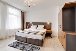 A modern bedroom with a large bed, a wooden wardrobe, and a chandelier. - Classy Apartment in Oberhausen (Oberhausen)