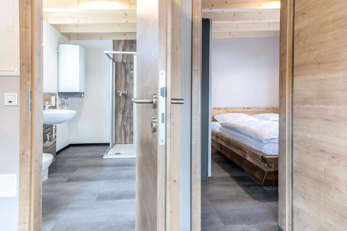 A modern bathroom with a sink, mirror, and shower.