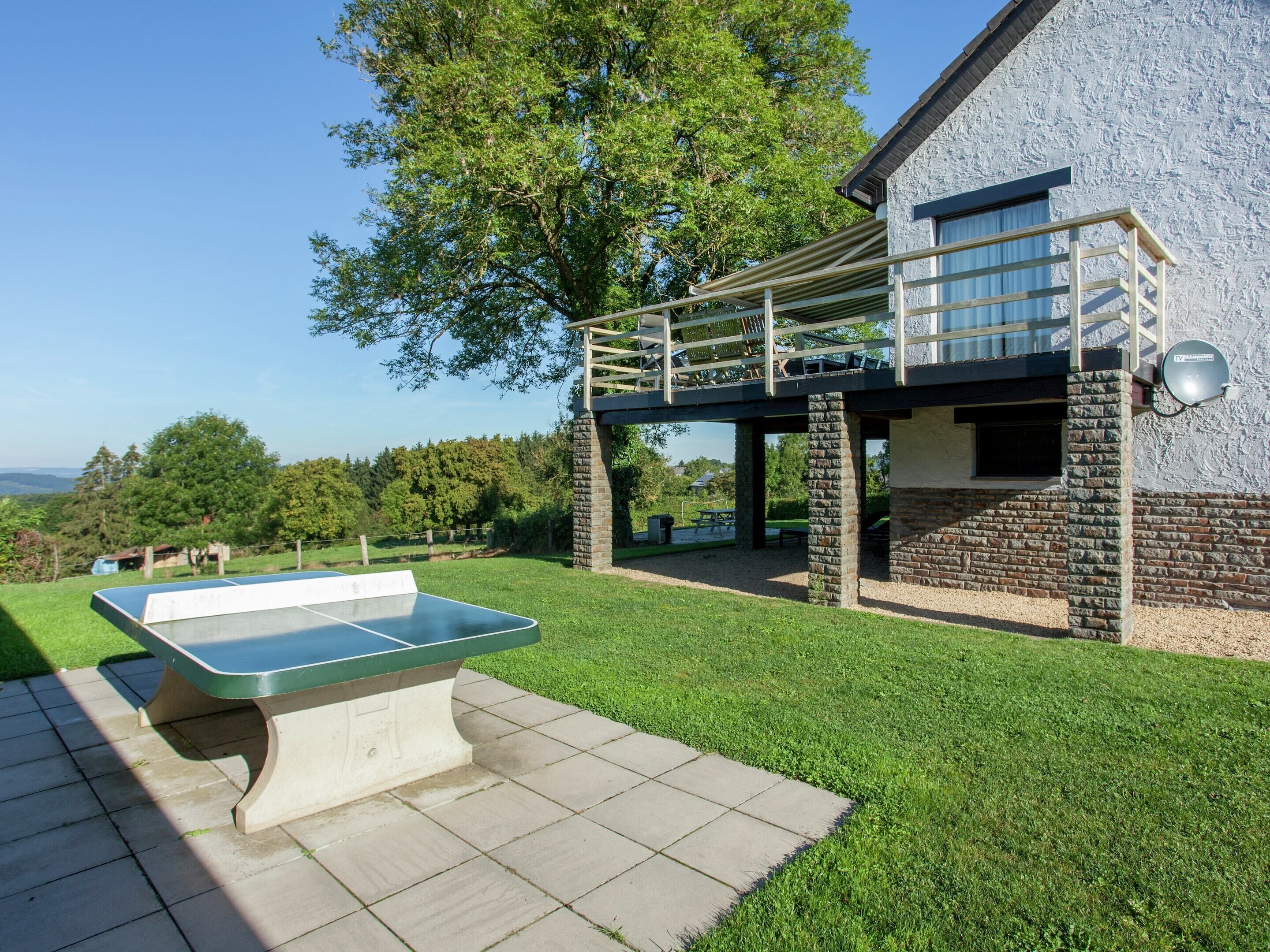A pool table in a backyard with a stone wall and a covered patio area.