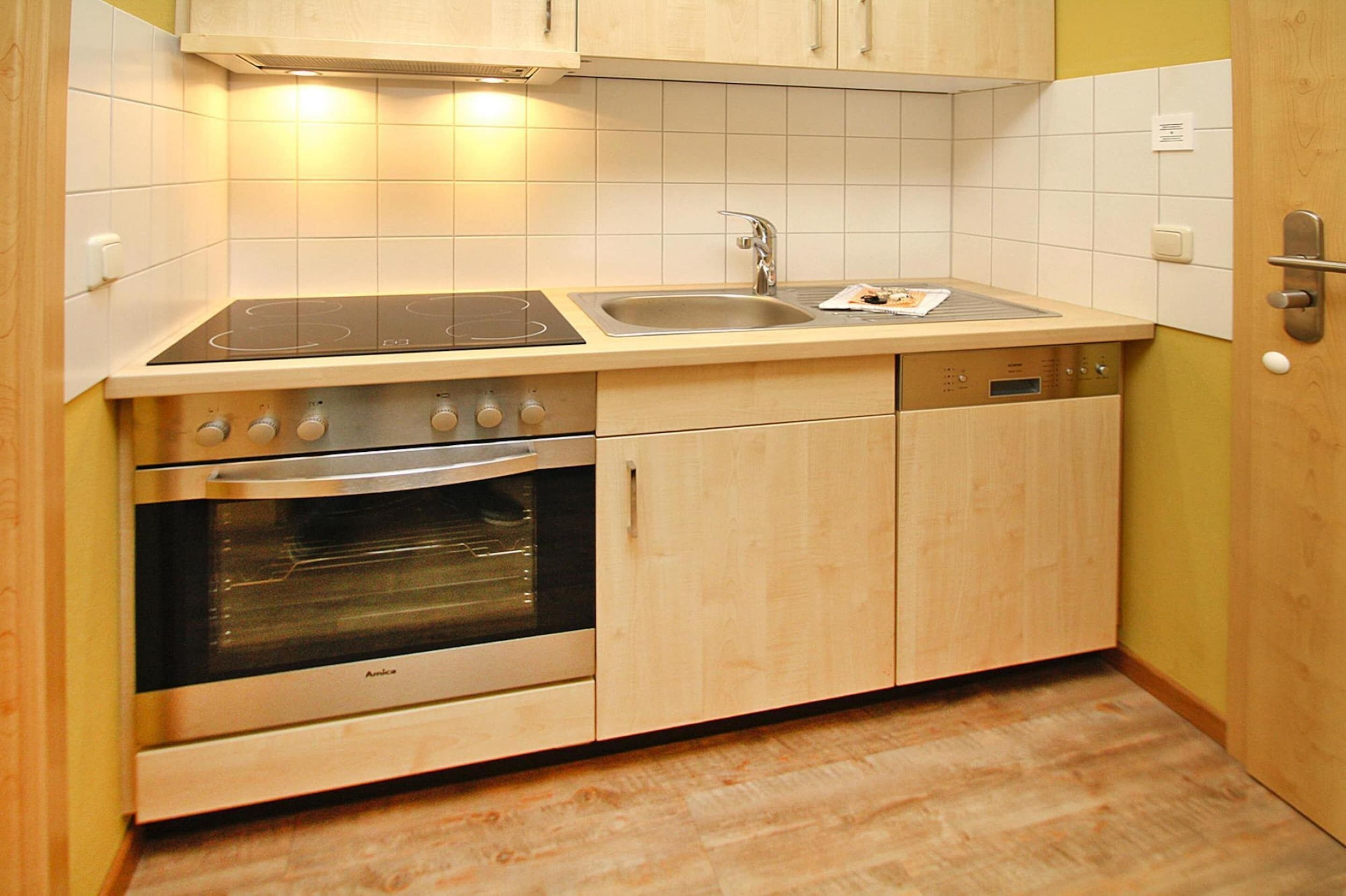 A kitchen with a stove, oven, sink, and dishwasher.