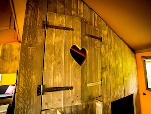 A wooden door with a heart-shaped cutout, metal hinges, and a small window. - Chalet Near Loonse and Drunense Duinen (Udenhout)