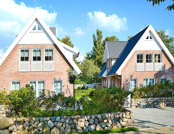 Two brick houses with pitched roofs and white window shutters.