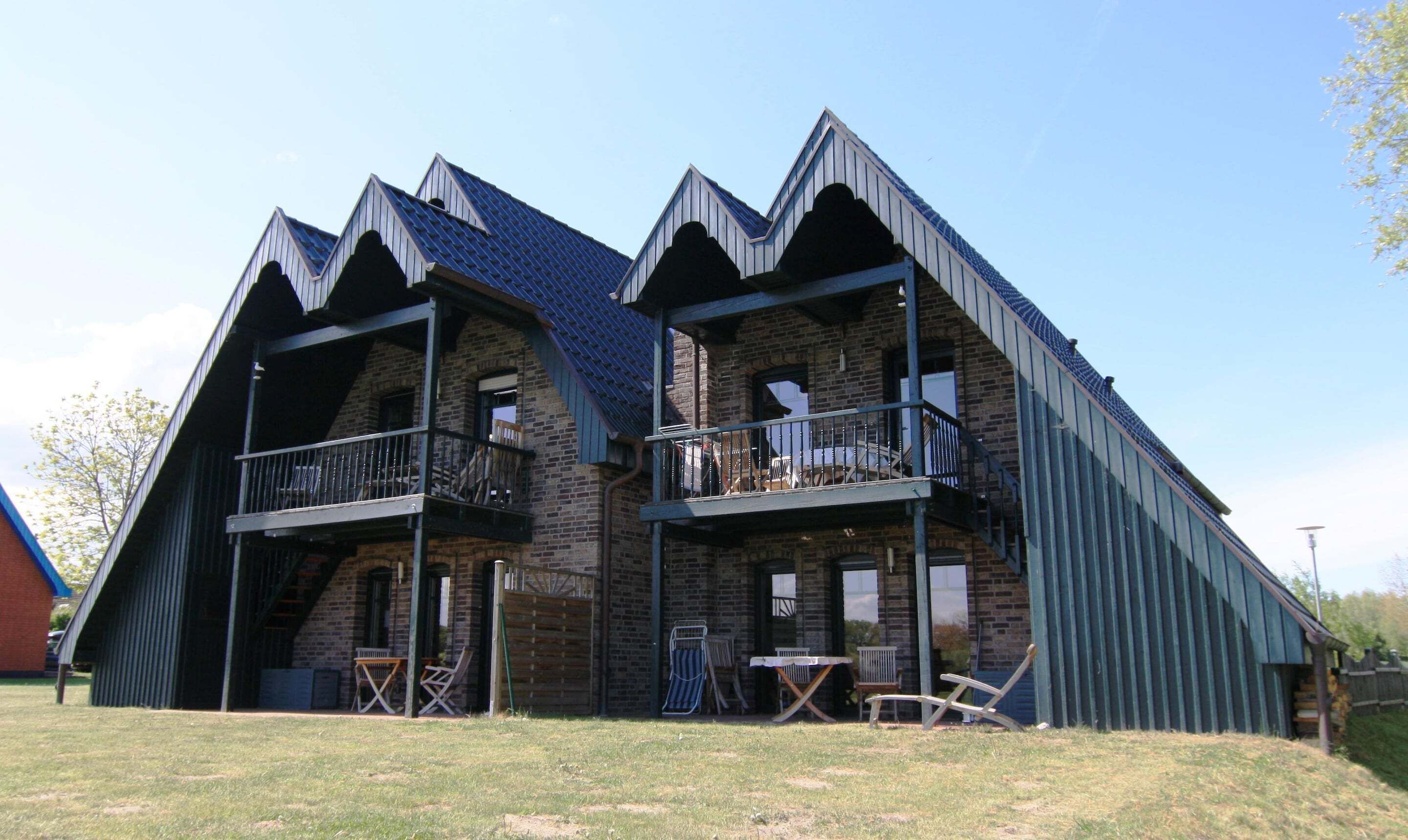 Un bâtiment à deux étages, doté d’un toit à forte pente et d’un balcon au deuxième étage.