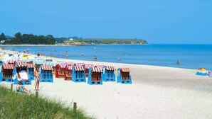 A beach with rows of blue beach huts and a sandy shore. - Semi-detached Houses, Boltenhagen (Boltenhagen)