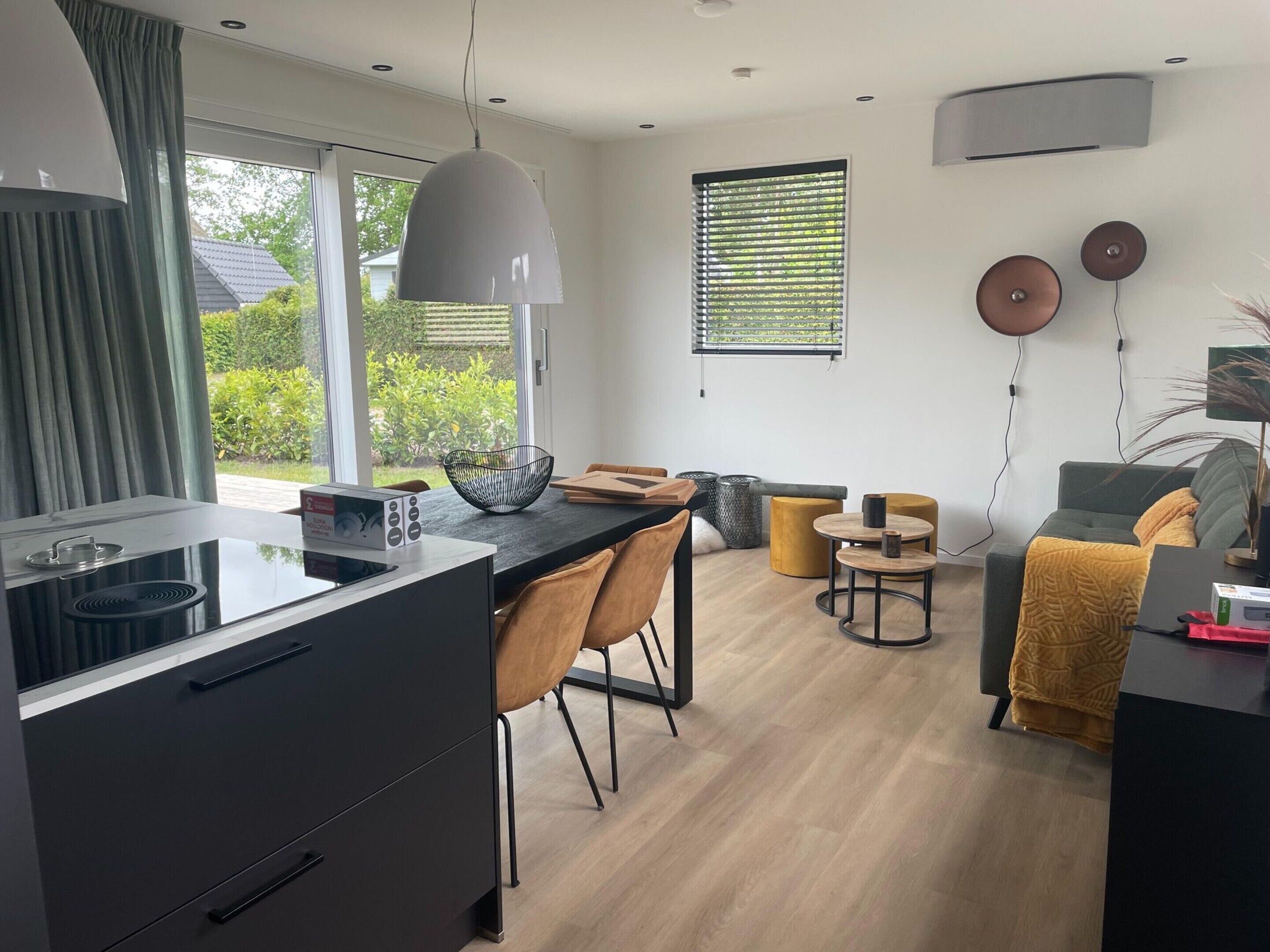 A modern kitchen with a dining area, a sofa, and a coffee table.