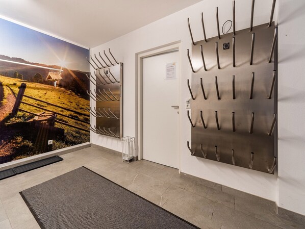 A hallway with a view of a scenic landscape, a wall-mounted coat rack, a door, and a textured mat on the floor. - Large Apartment in Sankt Georgen With Balcony (Bruck an der Grossglocknerstrasse)
