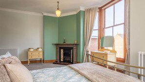 A bedroom with a bed, a dresser, a fireplace, and a window with curtains. - Host Stay Chatsworth Townhouse II (Carlisle)