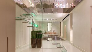 A modern interior with a glass staircase, a reception desk, and a minimalist design. - New Domus Historic Rome Palazzo Modern Luxury Near Piazza Navona (Rome)