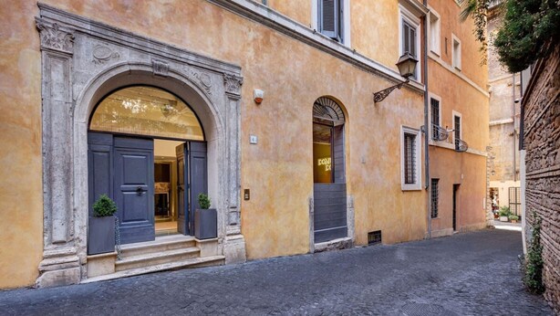 A narrow cobblestone street with a building featuring a large arched entrance and a smaller arched window. - New Domus Historic Rome Palazzo Modern Luxury Near Piazza Navona (Rome)
