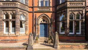 A historic building with a prominent blue door, arched windows, and stone architecture. - Host Stay Chatsworth Townhouse I (Carlisle)