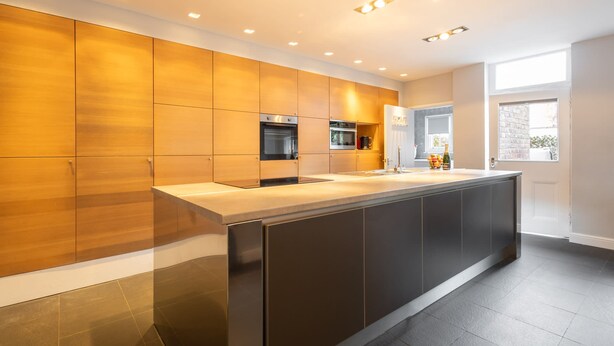 A modern kitchen with a central island, built-in appliances, and a large window providing natural light. - Host Stay Chatsworth Townhouse I (Carlisle)