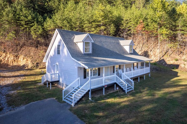 A two-story house with a porch, a small balcony, and a staircase leading to the entrance. - Lady Luck Lodge -Mountain View-Fire Pit-Open Covered Porch-Wifi (Whittier)