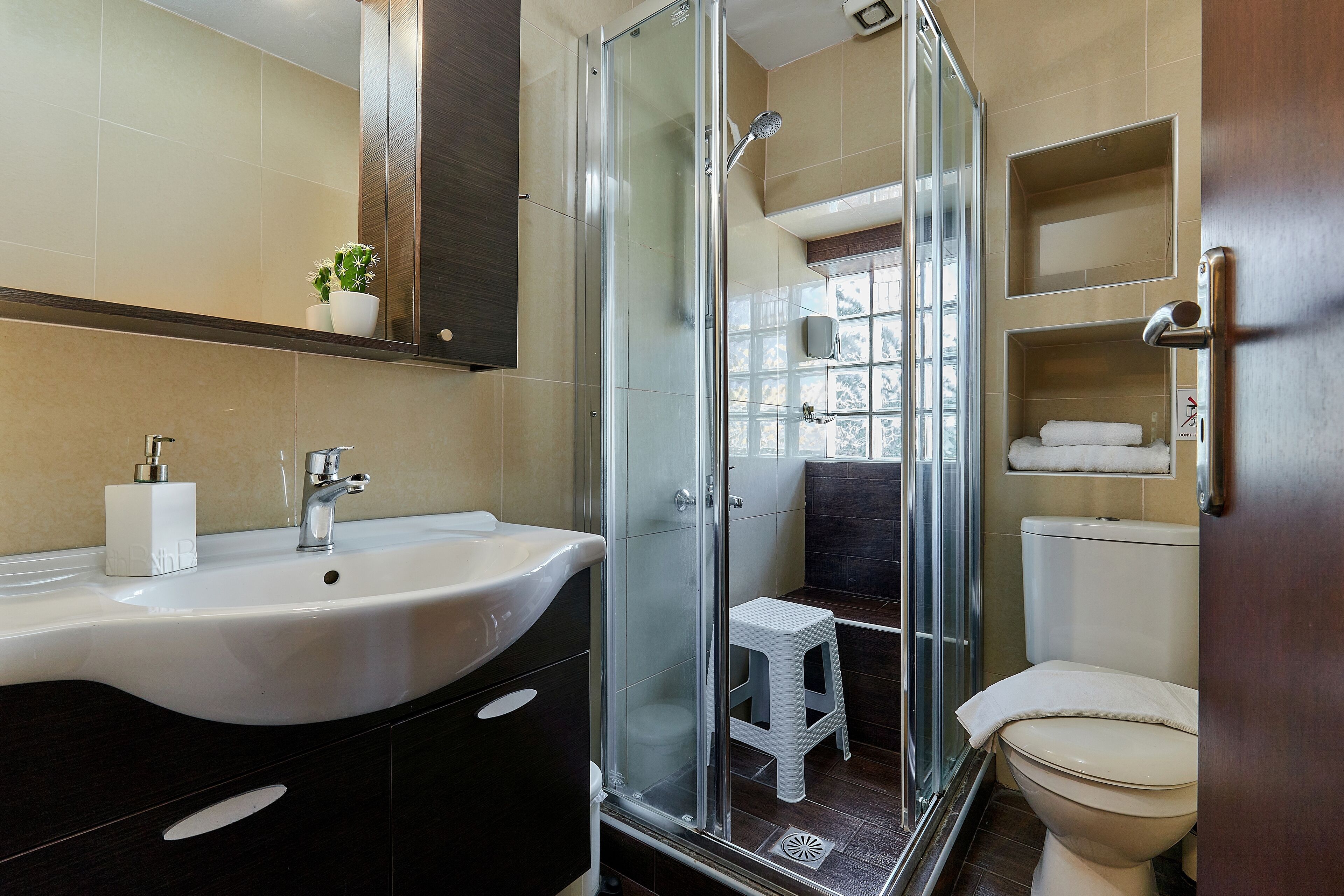 Ein modernes Badezimmer mit einer Duschkabine, einem weißen Waschbecken und einer Toilette.