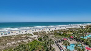 A beach resort with a swimming pool, beach umbrellas, and a view of the ocean. - 🏖️Oceanfront | Awesome Amenities | Great Views | Carolina Dunes 503🏖️ (Myrtle Beach)