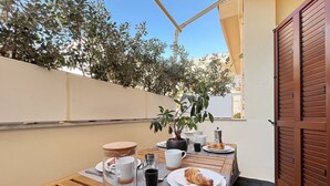 A wooden table set with a croissant, coffee cups, and a potted plant. - Solemar Sicilia - White Loft (Palermo)