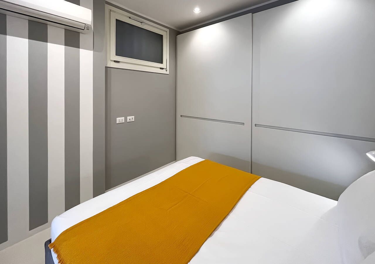 A bedroom with a bed, a window, and a wardrobe.