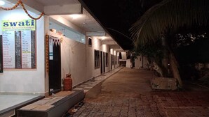 Un restaurante llamado Swati, con un cartel de menú, una escalera que conduce a la entrada y un camino pavimentado.